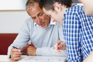 closeup of teacher helping male student with his work